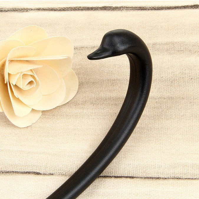 Black ladle stand close-up: curved spoon rest on round base