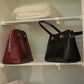 Adjustable wardrobe storage baffle shelf with white metal rails holding handbags