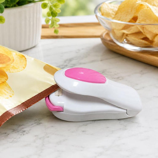 Portable mini heat sealing machine with white body and pink sealing pad, clamp-style base