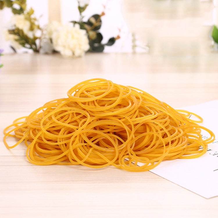 Yellow elastic rubber bands piled in a coil on white paper