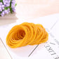 Yellow elastic rubber band coil, close-up on a white label card