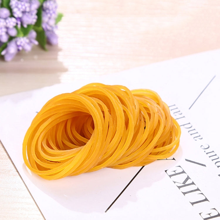 Yellow elastic rubber band coil, close-up on a white label card