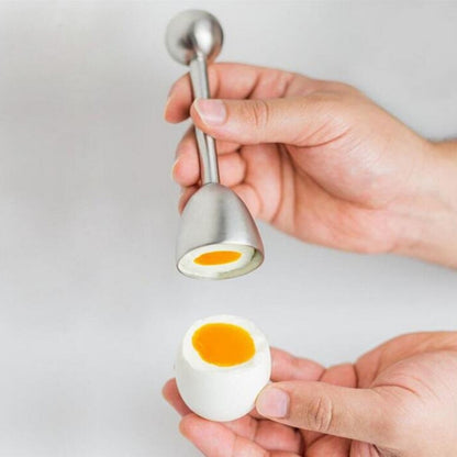 Stainless steel egg opener tool with dome end, pressed on an egg in hand