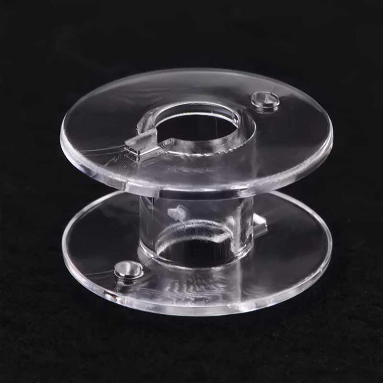 Clear plastic bobbin spool with round discs and center hub for sewing machine