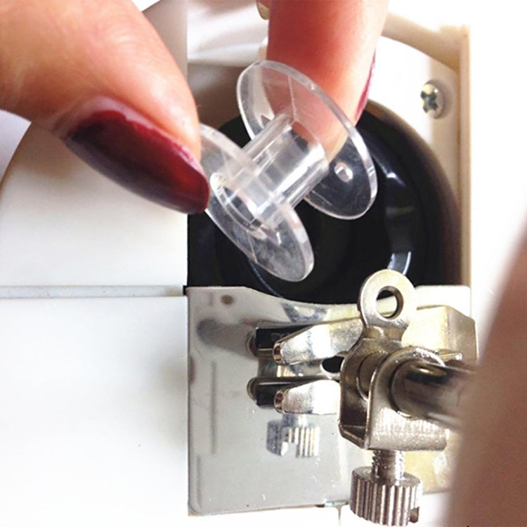 Hand placing a clear plastic bobbin into a sewing machine bobbin case