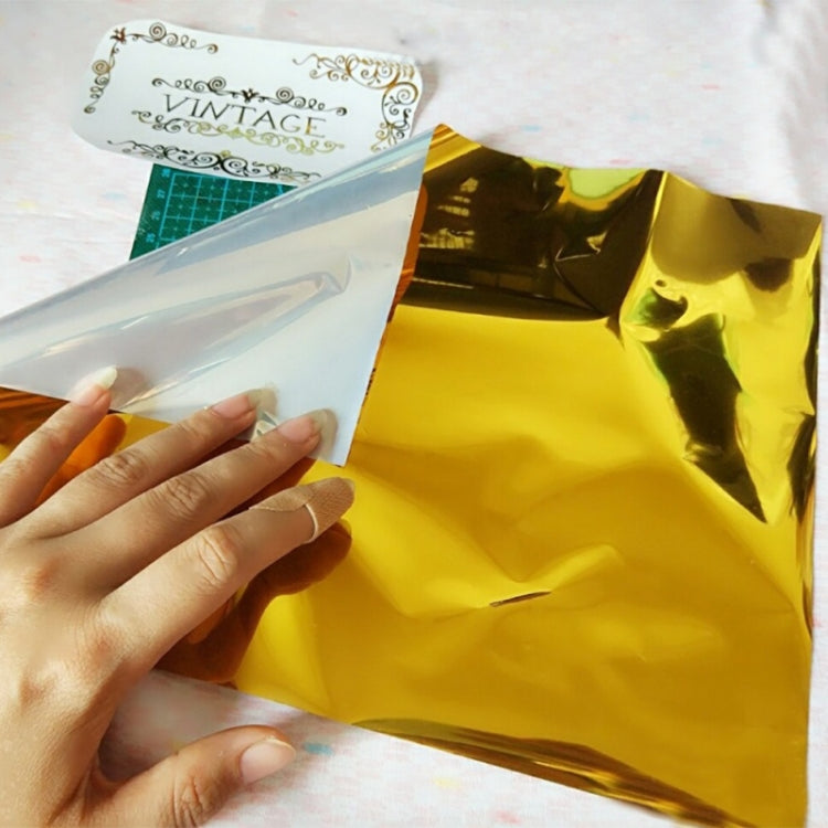 Gold and white metallic foil sheets held in hand for crafting