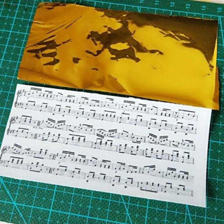 Gold metallic foil sheet over white paper with printed musical notes