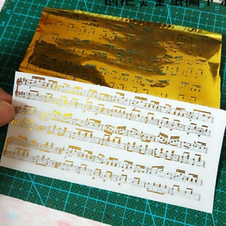 Gold foil paper with printed musical notes on white sheet underneath