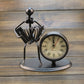 Retro small alarm clock on black metal stand with cream dial and Roman numeral markers