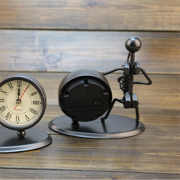 Retro small alarm clock showing back of black circular mechanism on metal stand