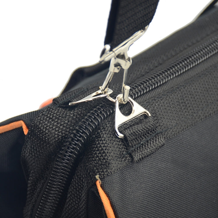 Zippered pocket detail on black tool bag with metal pull and orange accent stitching