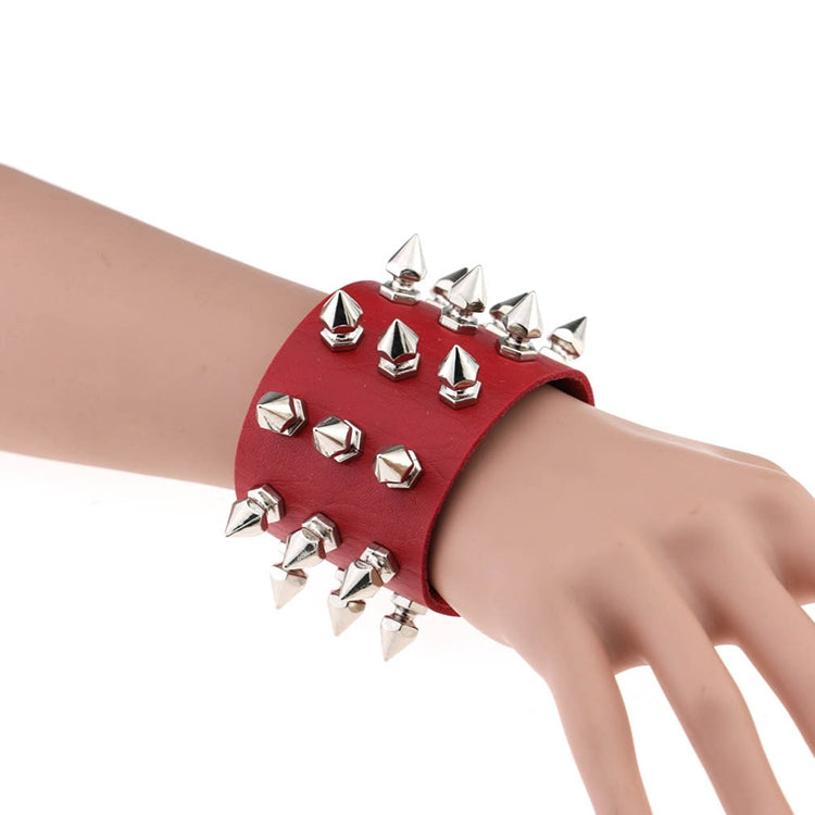 Red studded leather conical-tip spike bracelet with silver rivets on wrist