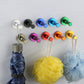 Round single wall hooks holding bath accessories, with colored posts and bases.