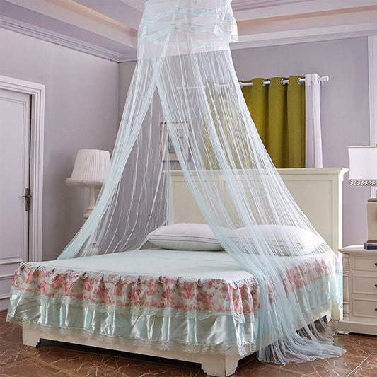 Light blue princess canopy mosquito net tent suspended over a bed with ruffled skirt