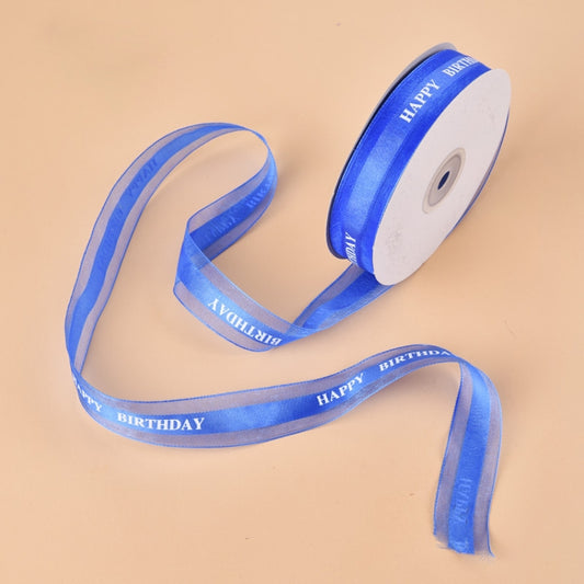 Blue satin ribbon roll with “HAPPY BIRTHDAY” printed along the ribbon edge