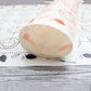 Rolled white baking mat with orange-red swirl and ring pattern