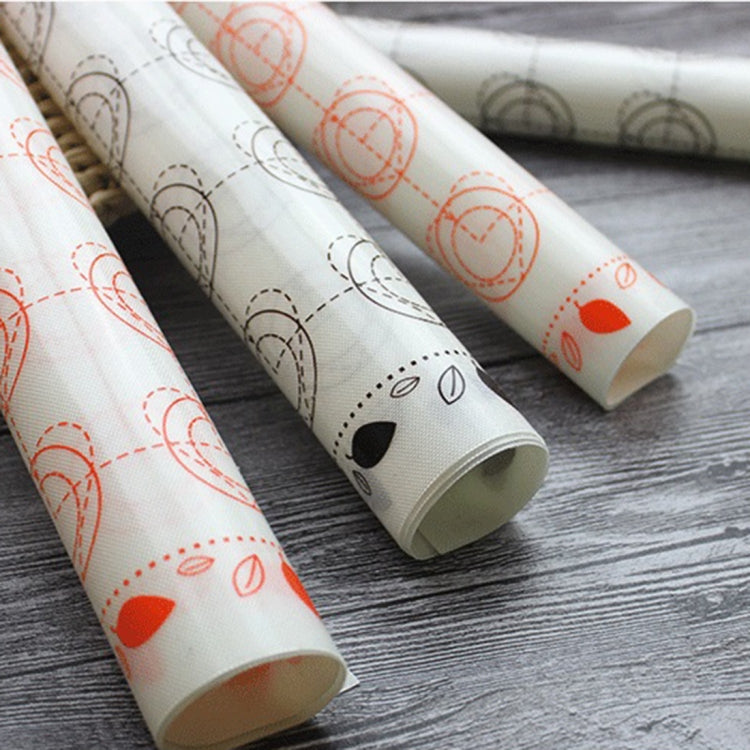 Rolled white nonstick baking mat with orange accents and gray animal face prints
