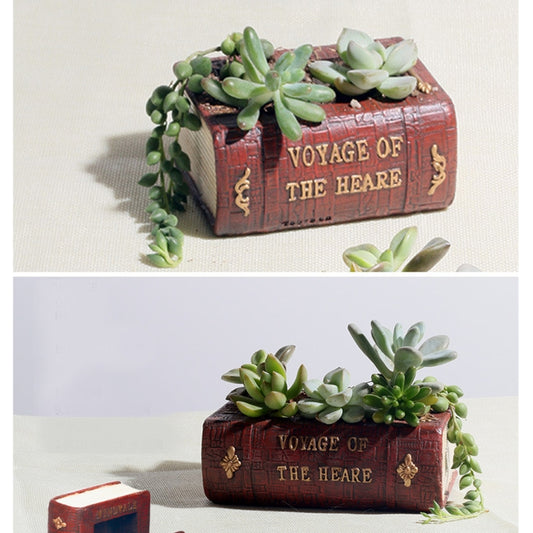 Red retro book-style planter with mixed succulents and trailing greenery over the edge