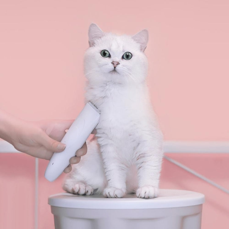 Handheld light gray electric pet grooming clipper with safety blade guard, with cat