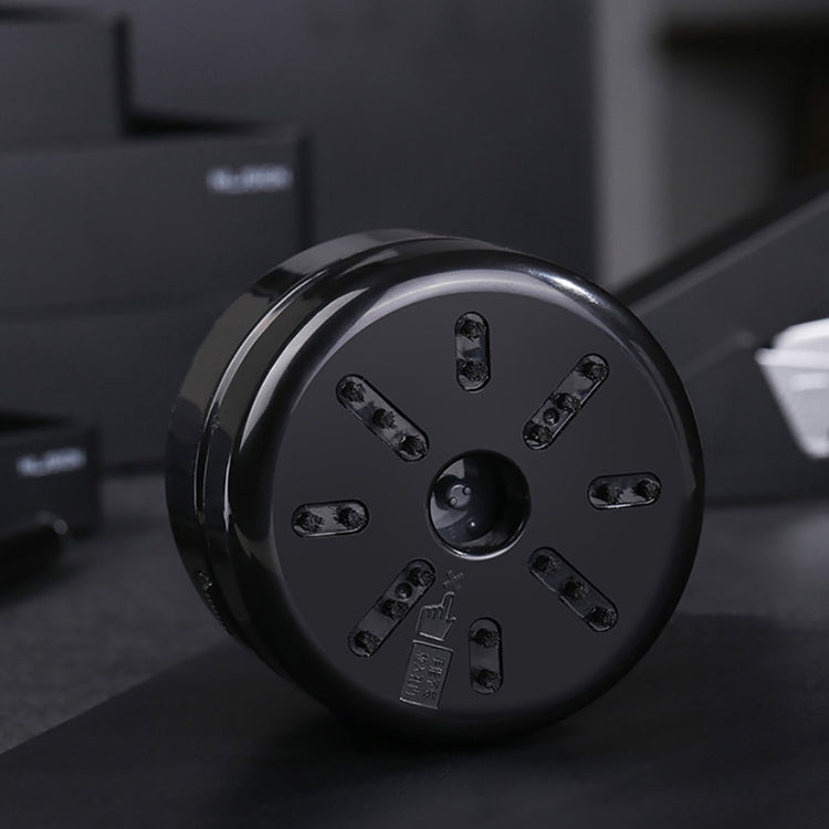 Round underside of mini desktop vacuum cleaner with intake holes and ports