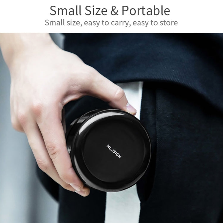 Black compact desktop cleaner being held, round lid facing the camera
