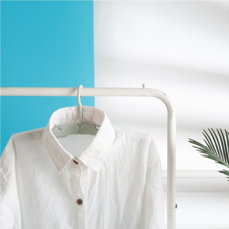 White foldable clothes drying hanger rack holding a white shirt on a bar
