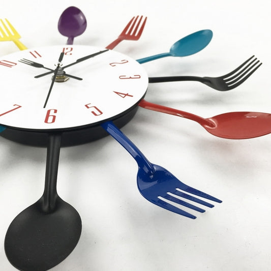 Colorful utensil wall clock close-up with white dial, red and black numbers, black hands