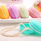 Macaron-style storage boxes with pearl beaded necklace in foreground