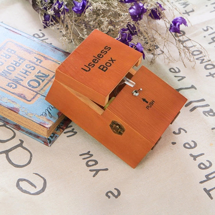 Wooden useless box with engraved "Useless Box" text and open lid