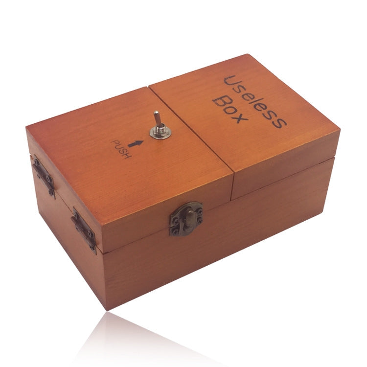 Orange wooden useless box with engraved "Useless Box" and push knob on lid