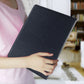 Black leather document folder being held in hand, front cover closed