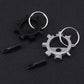 Two gear-style keychain tools (black and silver) with loop rings and screwdriver bits
