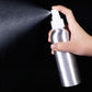 Hand holding aluminum fine-mist spray bottle releasing mist from nozzle