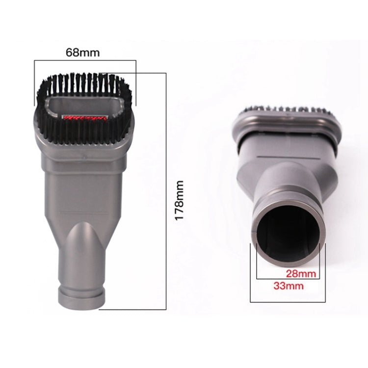 Compact grey vacuum brush head with black bristles and round opening, close-up