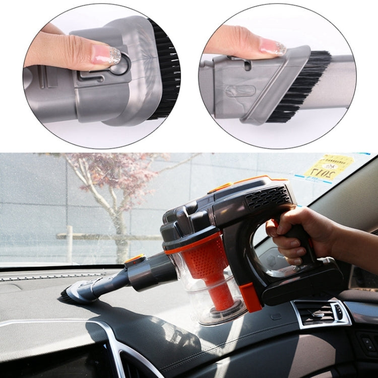 Hand holding handheld vacuum with grey brush attachment and black bristles