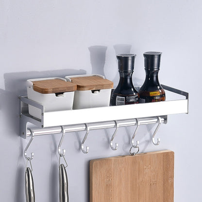 Wall hanging kitchen rack with silver bar and four hooks, with spice bottles and board