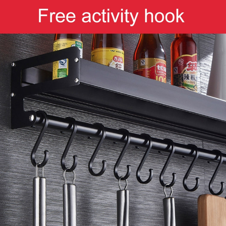 Black wall seasoning rack with a row of S hooks and spice bottles on top shelf