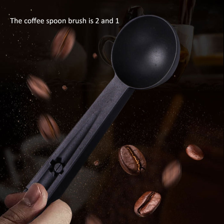 Black coffee cleaning spoon and brush tool with coffee particles around the heads