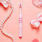 Pink children toothbrush with soft bristles and striped grip band on handle