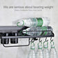 Black wall-mounted rack holding stacked water bottles and items on hanging hooks
