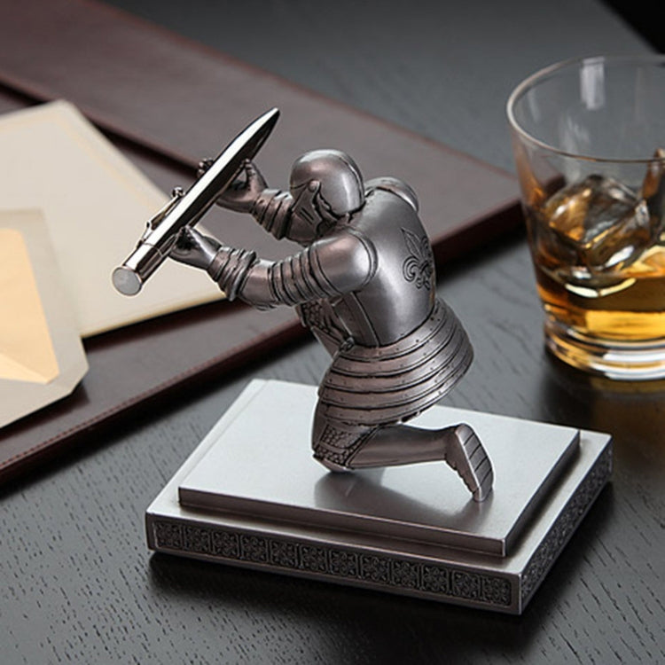 Knight-themed desktop pen holder with silver figurine holding a pen on a stand