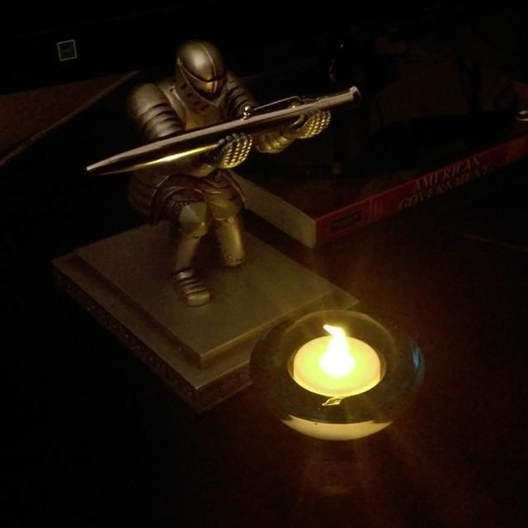 Gold-tone knight desktop pen holder with pen resting on a base