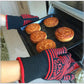 Heat-resistant BBQ glove holding a tray of baked pies in an oven