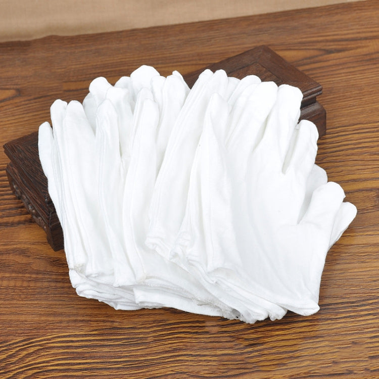 Stack of white cotton work gloves on a wooden surface