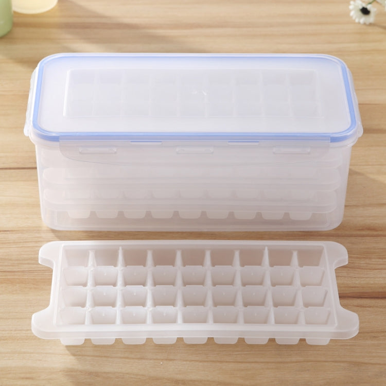 Multi-layer square ice mold tray inside clear storage box with blue rim