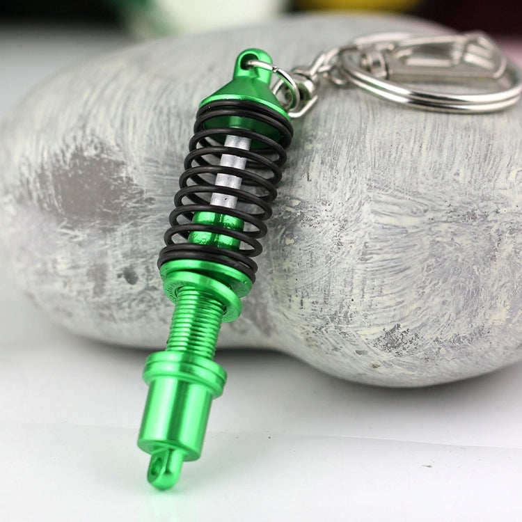 Green shock absorber keychain with black spring and silver key ring