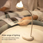 Cat-shaped LED desk night lamp with arched neck and warm glow on bedside