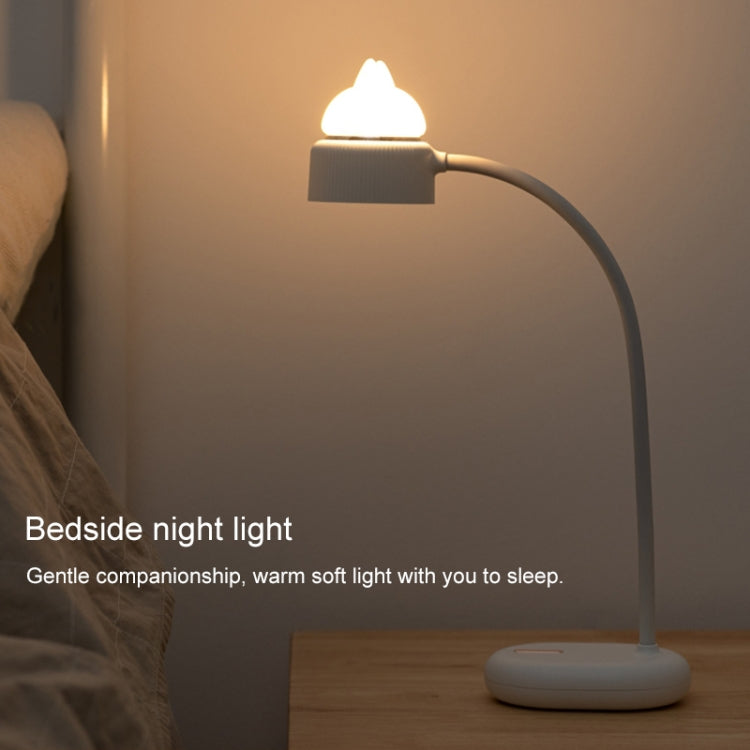 Warm glowing cat-shaped LED bedside night light on a round white base