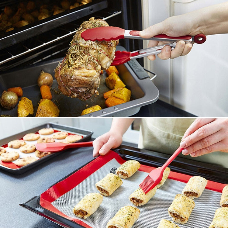Red silicone kitchen utensil set in oven tray and grilling, held by hands
