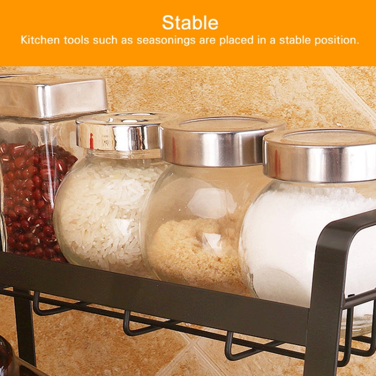 Three-tier black spice rack holding glass spice jars on wire shelves